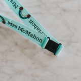 Personalised lanyards with safety break away clip and a lobster claw. Light Blue lanyard with rainbow design. Close up of safety break away clip and rainbow design