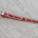 Personalised lanyards with safety break away clip and a lobster claw. Light pink lanyard with pencil design - Close up of print